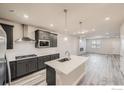 Modern kitchen with island, stainless steel appliances, and white cabinetry at 2822 South Flat Cir, Longmont, CO 80503