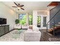 Open-concept living room with contemporary furniture, large windows, and a modern staircase at 2900 Inca St # 12, Denver, CO 80202