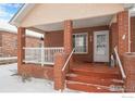 Inviting front porch with brick steps and a small railing at 302 Victoria St, Berthoud, CO 80513