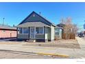 Quaint bungalow home with a covered porch and mature trees at 304 Mckinley Ave, Fort Lupton, CO 80621