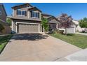 Two-story house with a tan exterior, two-car garage, and landscaping at 3557 Blanca Peak Dr, Superior, CO 80027