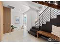 Light-filled entryway, modern staircase, and wood accent wall at 104 Old Sunshine Trl, Boulder, CO 80302