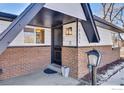 Modern front entrance with black door and brick exterior at 10690 W 47Th Pl, Wheat Ridge, CO 80033