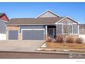 Two-story home with gray siding, stone accents, and a two-car garage at 1352 Murrlet St, Berthoud, CO 80513