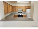 Functional kitchen featuring wood cabinets and a breakfast bar at 1419 Red Mountain Dr # 71, Longmont, CO 80504