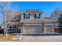 Two-story house with a beige exterior, a three-car garage, and a manicured lawn at 1420 Hickory Dr, Erie, CO 80516