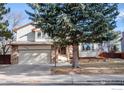 Two-story house with stone accents and a landscaped yard at 1830 Tyler Ave, Louisville, CO 80027