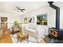 Living room with wood floors, wood burning stove, and staged furniture at 305 Jackson Ave, Firestone, CO 80520