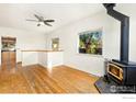 Living room with wood floors, wood burning stove and view into kitchen at 305 Jackson Ave, Firestone, CO 80520