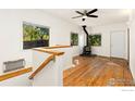 Upstairs view of living room with wood floors and wood burning stove at 305 Jackson Ave, Firestone, CO 80520