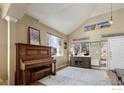 Bright living room with vaulted ceiling, piano, and large windows at 6646 Bean Mountain Ln, Boulder, CO 80301