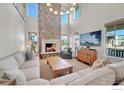 Bright living room with large stone fireplace and high ceilings at 934 Larkspur Ln, Louisville, CO 80027