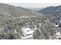 Stunning aerial view of a home nestled in a snow-covered mountain landscape at 130 Seven Hills Dr, Boulder, CO 80302