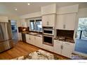 White kitchen cabinets, granite countertops, and double ovens at 130 Seven Hills Dr, Boulder, CO 80302