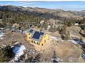 Aerial view of a home with solar panels and a beautiful mountain backdrop at 1335 Deer Trail Rd, Boulder, CO 80302