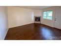 Simple living room with hardwood floors and corner fireplace at 1601 Great Western Dr # A7, Longmont, CO 80501