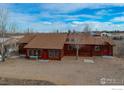 Aerial view of a log home with a large yard and outbuildings at 2244 County Road 12, Erie, CO 80516