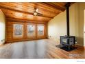 Spacious living area with wood floors, wood ceiling, and wood burning stove at 2244 County Road 12, Erie, CO 80516