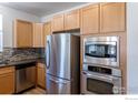 Stainless steel appliances and wood cabinets in kitchen at 2850 E College Ave # 402, Boulder, CO 80303