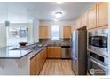 Modern kitchen with wood cabinets and stainless steel appliances at 2850 E College Ave # 402, Boulder, CO 80303