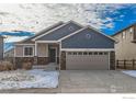 Two-story Craftsman home with gray and tan siding, stone accents, and a two-car garage at 413 Canyonlands St, Berthoud, CO 80513