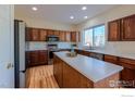 Kitchen boasts wood cabinets, stainless steel appliances, and an island at 614 Americana Rd, Longmont, CO 80504