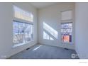 Bright living room featuring large windows and neutral carpeting at 614 Americana Rd, Longmont, CO 80504