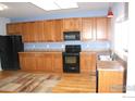 Eat-in kitchen with wood cabinets and light flooring at 6297 Clayton Cir, Frederick, CO 80530