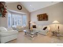 Bright living room with vaulted ceiling, white couches, and a bay window at 630 S Snowmass Cir, Superior, CO 80027