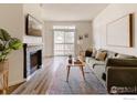 Bright living room featuring a fireplace, wood floors, and a large window at 7431 Singing Hills Dr # 7431, Boulder, CO 80301