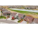 Aerial view showcasing homes around a lake and golf course at 8027 Tamarac Ct, Thornton, CO 80602