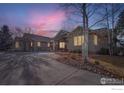 Beautiful home exterior at sunset, showcasing stone and stucco at 8777 Comanche Rd, Niwot, CO 80503