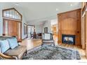 Spacious living room with hardwood floors, fireplace, and ample natural light at 8777 Comanche Rd, Niwot, CO 80503