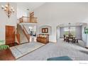 Two-story entryway with staircase, hardwood floors, and chandelier at 909 Glenarbor Cir, Longmont, CO 80504