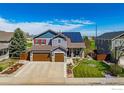 Two-story house with solar panels, landscaped yard, and attached garage at 909 Glenarbor Cir, Longmont, CO 80504