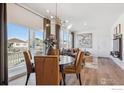 Bright dining room with a modern wooden table, mustard yellow chairs, and large windows at 916 Andrews Crest Dr, Berthoud, CO 80513