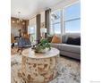 Living room featuring a round wooden coffee table and gray sofa with decorative pillows at 916 Andrews Crest Dr, Berthoud, CO 80513