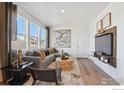 Open living room with gray sectional sofa, wooden coffee table, and large windows at 916 Andrews Crest Dr, Berthoud, CO 80513