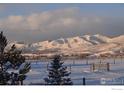 Snowy pasture with mountain views and wooden fence at 10619 N 65Th St, Longmont, CO 80503