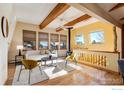 Bright living room with wood beams, a wood stove, and large windows at 12041 Twilight St, Longmont, CO 80503