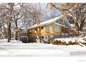 Gray and yellow two-story home with a detached garage, covered in snow at 1520 Baseline Rd, Boulder, CO 80302