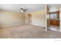 Open living room with view into kitchen and access to hallway at 1537 Hilltop Dr, Longmont, CO 80504