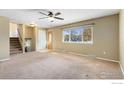 Spacious living room featuring neutral carpeting and large window at 1537 Hilltop Dr, Longmont, CO 80504