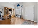 Bright home office with built-in shelving and hardwood floors at 2062 Indian Paintbrush Way, Erie, CO 80516