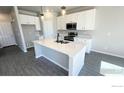 Modern kitchen with stainless steel appliances, an island and white cabinetry at 2303 Peregrine Dr, Brighton, CO 80601