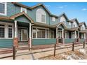 Green townhome exterior with brick accents and a welcoming front porch at 2855 Rock Creek Cir # 257, Superior, CO 80027