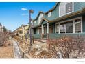 Row of townhomes with green siding and brick accents, showcasing a community feel at 2855 Rock Creek Cir # 257, Superior, CO 80027