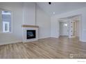 Living room with hardwood floors, a fireplace, and views into the entryway at 497 Muirfield Cir, Louisville, CO 80027