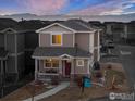 Two-story house with red door, light brown siding, and a small porch at 6108 Summit Peak Ct # 102, Frederick, CO 80516