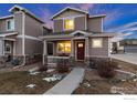 Two-story house with red door, light brown siding, and a small porch at 6108 Summit Peak Ct # 102, Frederick, CO 80516